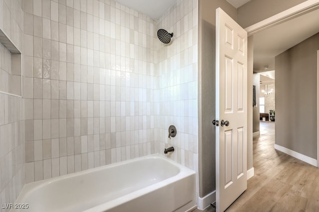 bathroom featuring tiled shower / bath combo and hardwood / wood-style flooring