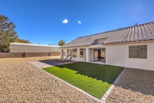 rear view of house with a patio and a yard