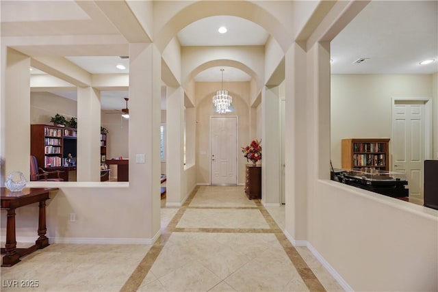 entryway featuring ceiling fan with notable chandelier