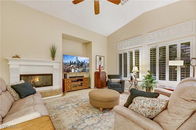 living room featuring ceiling fan, lofted ceiling, and a fireplace