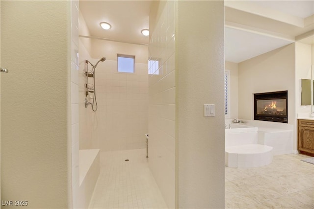 bathroom with vanity, a tile shower, and a multi sided fireplace