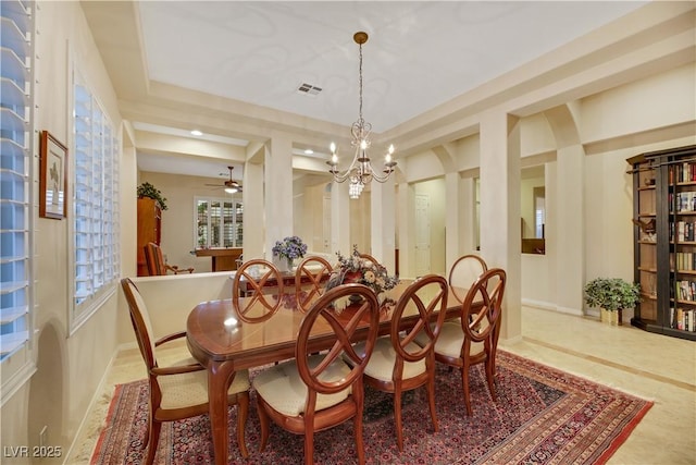 dining space with an inviting chandelier and a raised ceiling