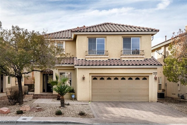 mediterranean / spanish-style house featuring a garage and central air condition unit