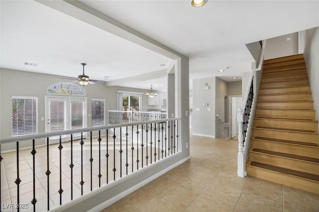 hall with a chandelier and light tile patterned floors