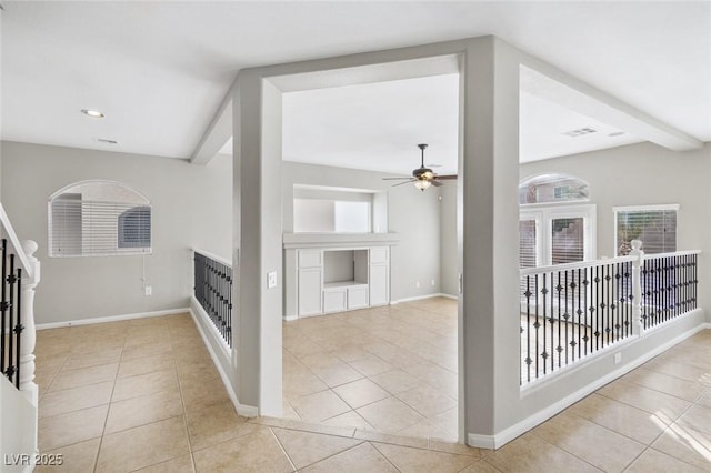 interior space with a wealth of natural light, beam ceiling, and light tile patterned floors