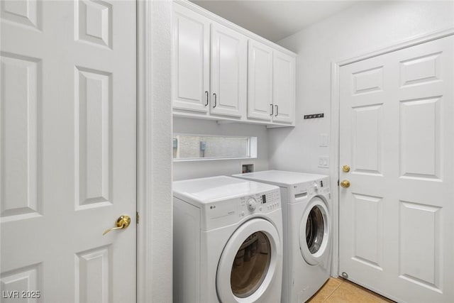 laundry room with washing machine and dryer, cabinets, and light tile patterned flooring