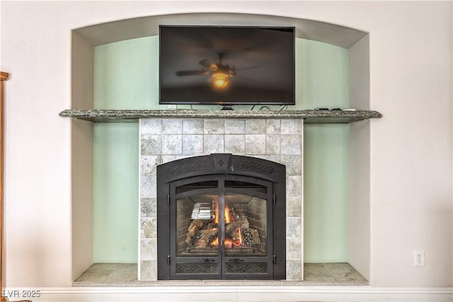 interior details featuring a tiled fireplace