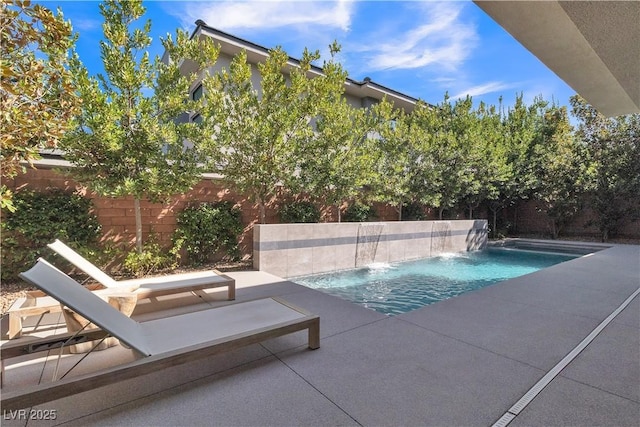 view of swimming pool with pool water feature and a patio