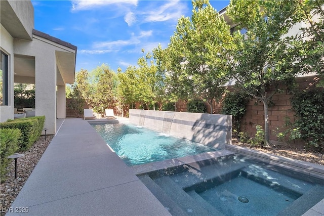 view of pool with an in ground hot tub, pool water feature, and a patio area