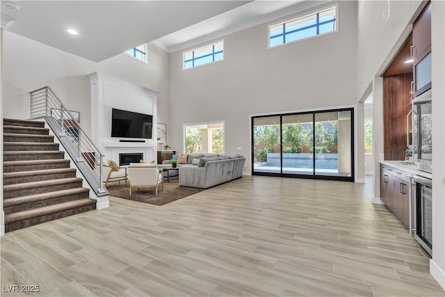 living room with crown molding and light wood-type flooring