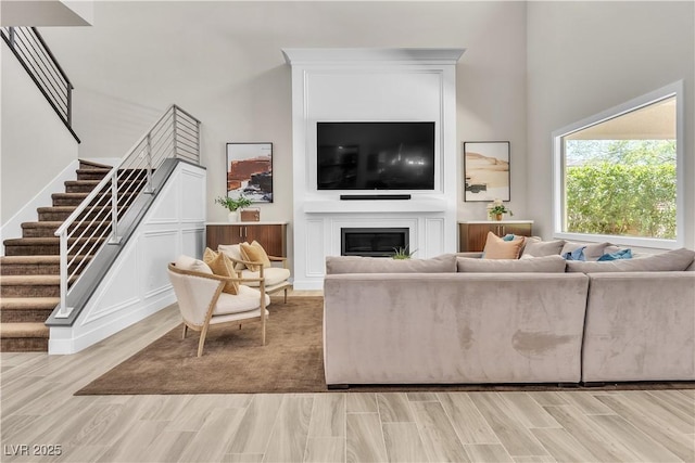 living room featuring a towering ceiling and light hardwood / wood-style floors