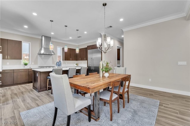 dining space featuring ornamental molding and light hardwood / wood-style floors