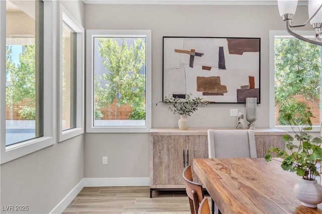 dining space with light hardwood / wood-style floors and a notable chandelier