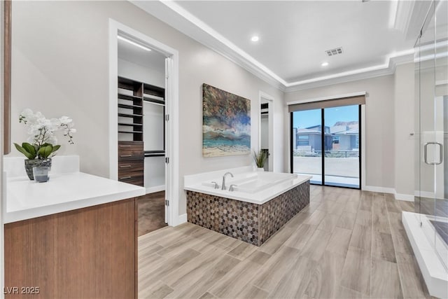 bathroom with hardwood / wood-style flooring, ornamental molding, and independent shower and bath