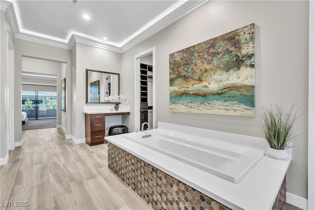 bathroom featuring crown molding, a tub, hardwood / wood-style floors, and vanity