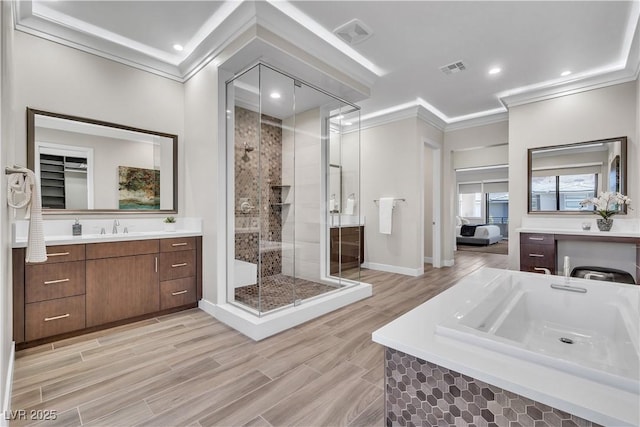 bathroom with vanity, crown molding, and a shower with shower door