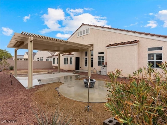 rear view of property featuring a patio area, fence, a pergola, and stucco siding