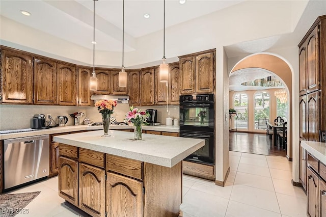 kitchen featuring decorative light fixtures, a center island, dishwasher, black double oven, and backsplash