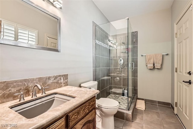 bathroom with vanity, a shower with shower door, tile patterned floors, and toilet