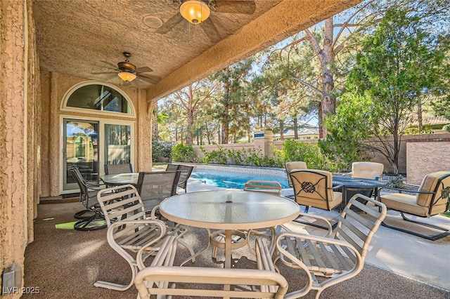 view of patio with ceiling fan and a fenced in pool