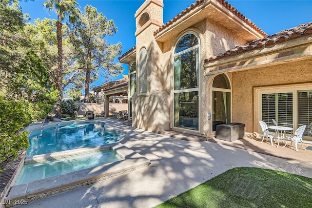 rear view of house featuring a fenced in pool and a patio