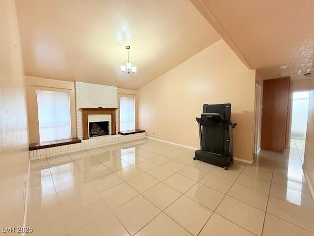 unfurnished living room featuring light tile patterned flooring, lofted ceiling, a textured ceiling, a notable chandelier, and a fireplace