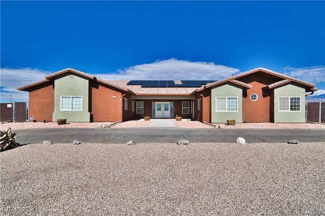 single story home featuring solar panels