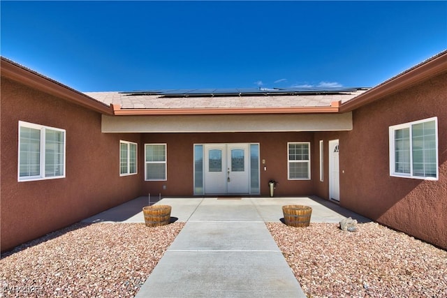 view of exterior entry with a patio area and solar panels