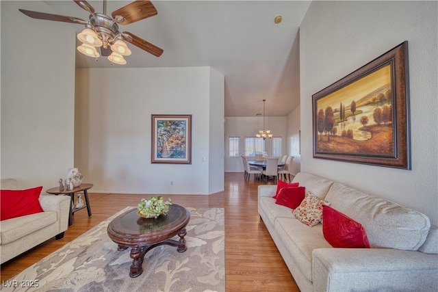 living room featuring hardwood / wood-style flooring and ceiling fan with notable chandelier