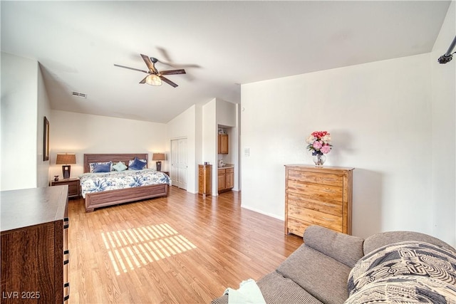 bedroom featuring lofted ceiling, light hardwood / wood-style flooring, and ceiling fan