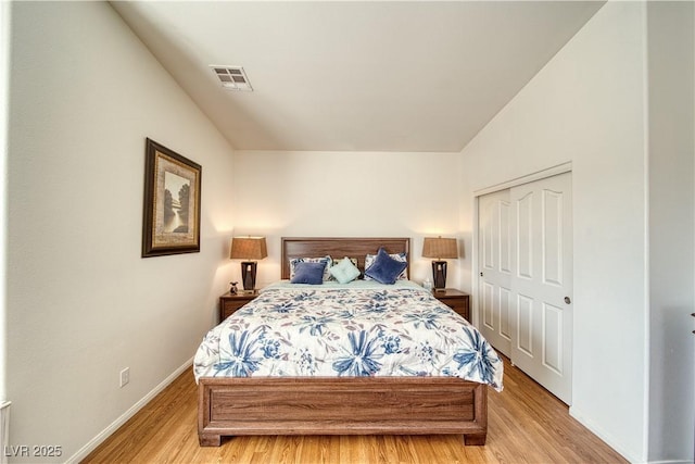 bedroom with light hardwood / wood-style floors and a closet