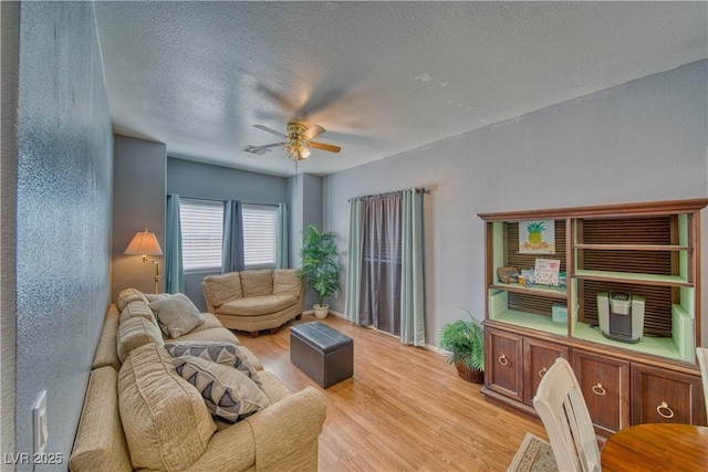 living room featuring a textured ceiling, light hardwood / wood-style floors, and ceiling fan