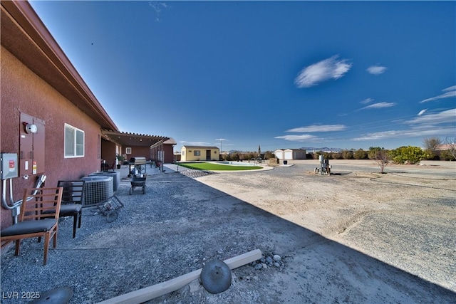 view of yard with central AC and a patio area