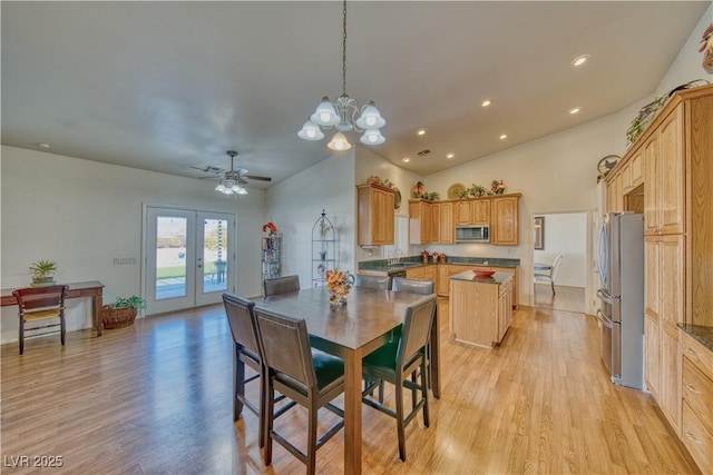 dining area featuring french doors, sink, vaulted ceiling, light hardwood / wood-style floors, and ceiling fan with notable chandelier