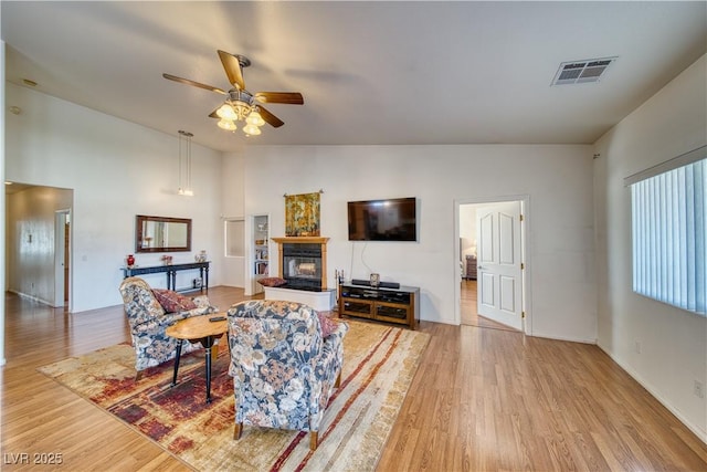 living room with lofted ceiling, hardwood / wood-style flooring, and ceiling fan