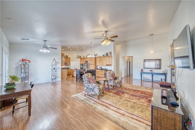 living room featuring ceiling fan and light hardwood / wood-style flooring