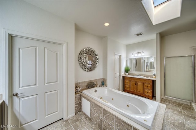 bathroom with vanity, shower with separate bathtub, and a skylight