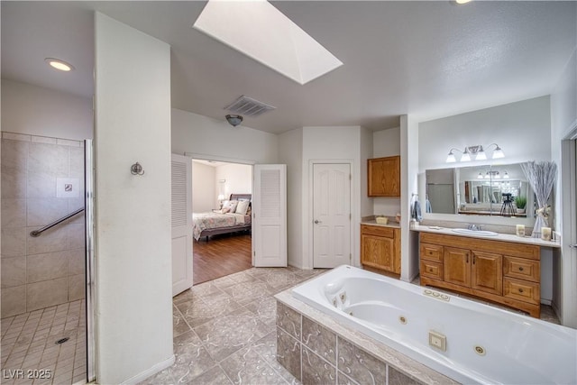 bathroom with vanity, a skylight, and independent shower and bath