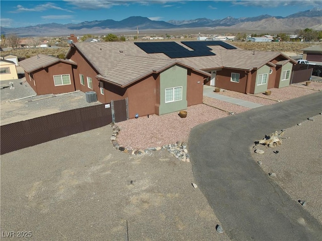 view of front of property with a mountain view, central AC, and solar panels