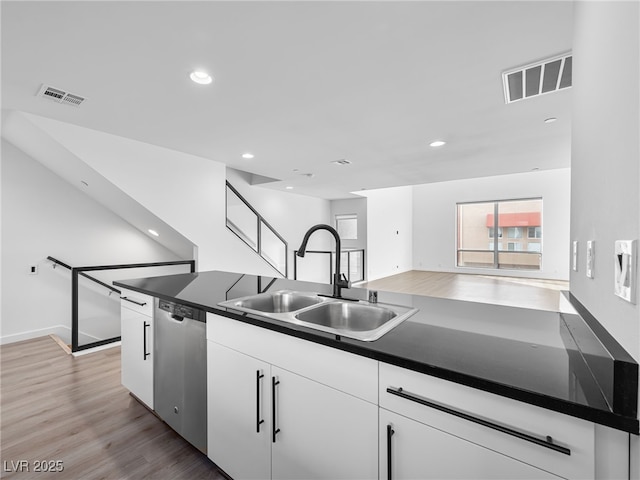 kitchen featuring light wood-type flooring, white cabinetry, dishwasher, and sink