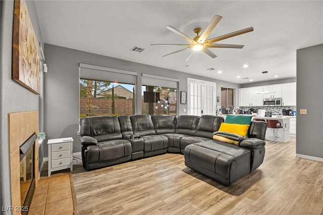 living room featuring light hardwood / wood-style flooring and ceiling fan