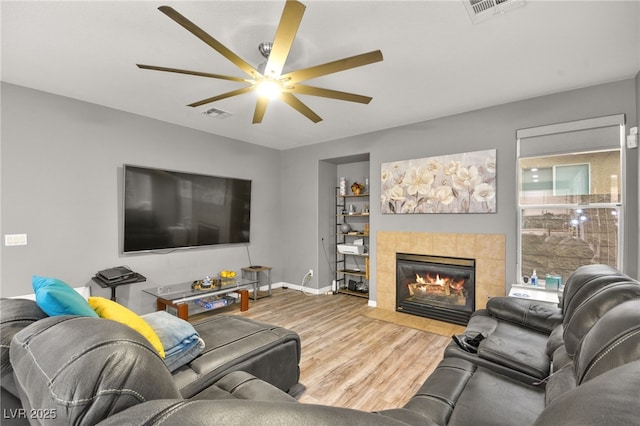 living room with hardwood / wood-style floors, a fireplace, and ceiling fan