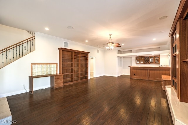 unfurnished living room featuring dark hardwood / wood-style flooring, ornamental molding, and ceiling fan