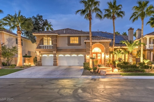 mediterranean / spanish-style home featuring a garage and solar panels