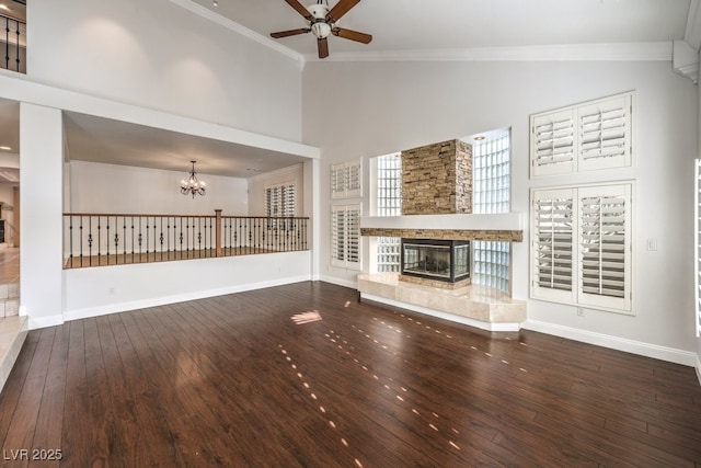 unfurnished living room featuring ornamental molding, a stone fireplace, hardwood / wood-style floors, and high vaulted ceiling