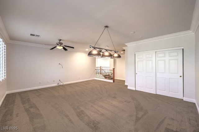 unfurnished dining area with crown molding, ceiling fan, and dark colored carpet