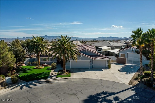 view of front facade featuring a mountain view, a garage, and a front lawn