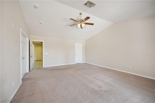 spare room featuring vaulted ceiling, light carpet, and ceiling fan