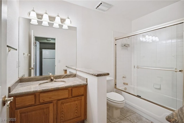 full bathroom featuring tile patterned flooring, enclosed tub / shower combo, vanity, and toilet