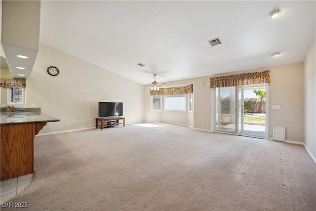 unfurnished living room with ceiling fan, light colored carpet, and vaulted ceiling